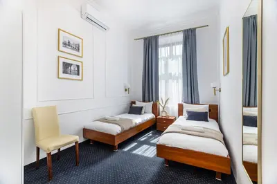 a hotel room with two beds and a chair at BoB Elite - Szpitalna in Kraków
