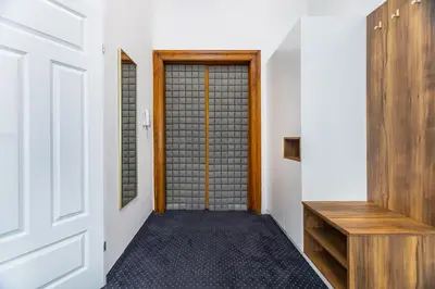 a hallway with a door and a wooden bench at BoB Elite - Szpitalna in Kraków