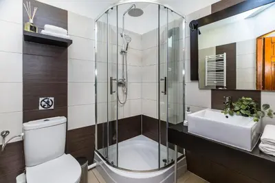 a bathroom with a shower and a toilet and a sink at BoB Elite - Szpitalna in Kraków