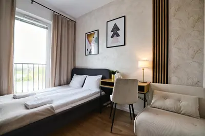 a bedroom with a bed and a desk and a window at Apartament SUNSET 79 by Housine in Zator