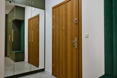 a hallway with two wooden doors and a mirror at Apartament SUNSET 79 by Housine in Zator