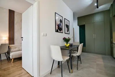 a dining room with a table and chairs at Apartament SUNSET 79 by Housine in Zator