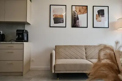 a living room with a couch and four pictures on the wall at Apartament SUNSET 79 by Housine in Zator