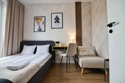 a bedroom with a bed and a desk and a chair at Apartament SUNSET 79 by Housine in Zator