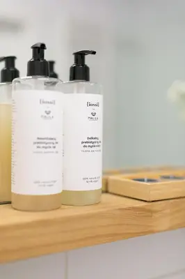 three bottles ofodorizers sitting on a wooden shelf at Malila Premium Apartments Cracow City Center Pawia 34 in Kraków