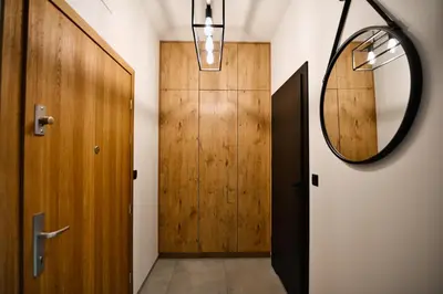 a hallway with a wooden door and a mirror at Apartament Zator 5 by Housine in Zator