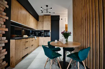 a kitchen with a table and some green chairs at Apartament Zator 5 by Housine in Zator