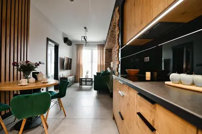 a kitchen with a counter and a table and chairs at Apartament Zator 5 by Housine in Zator