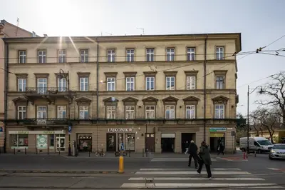 a large building with people crossing a street in front at Apartamenty Starowiślna 1, Kraków Main Square in Kraków