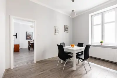 a white dining room with a white table and chairs at Apartamenty Starowiślna 1, Kraków Main Square in Kraków