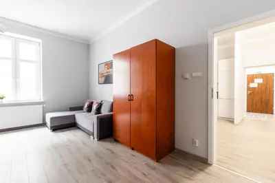 a living room with a wooden cabinet and a couch at Apartamenty Starowiślna 1, Kraków Main Square in Kraków