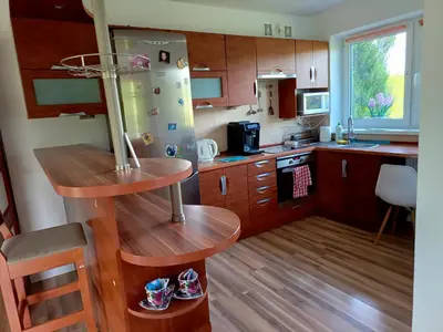 a kitchen with wooden cabinets and a refrigerator at W Rajbrocie u Ewusi in Rajbrot