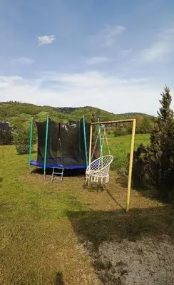 a playground with two swings in a field at W Rajbrocie u Ewusi in Rajbrot
