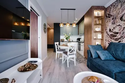 a living room with a blue couch and a kitchen at Apartament Bulwary317 in Oświęcim
