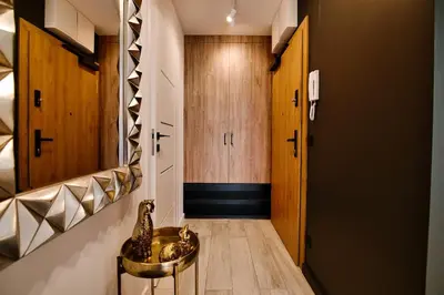 a hallway with a room with wooden cabinets and a table at Apartament Bulwary317 in Oświęcim