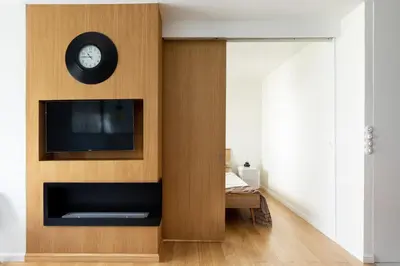 a living room with a tv and a clock on a wall at Miejska Cisza Urban Silence in Kraków