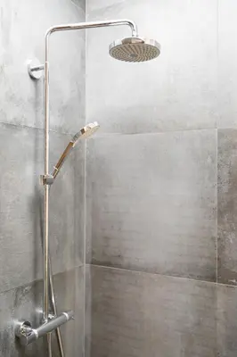 a shower with a glass door and a shower head at Miejska Cisza Urban Silence in Kraków