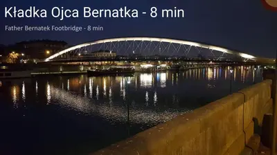 a bridge over a river at night at Miejska Cisza Urban Silence in Kraków