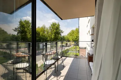a balcony with chairs and a view of a street at Miejska Cisza Urban Silence in Kraków
