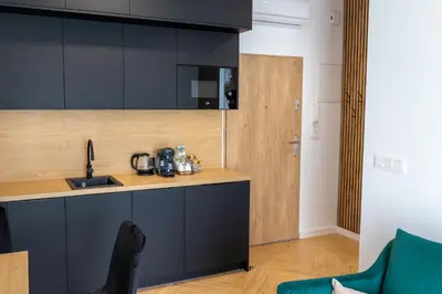 a kitchen with black cabinets and a counter top at DS Apartamenty Jaśminowa in Zator