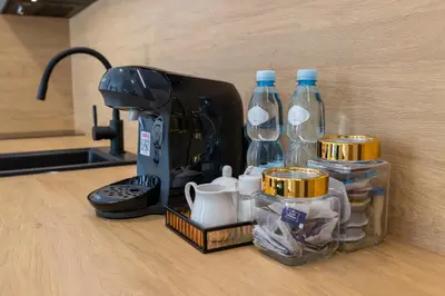 a counter with a coffee maker and bottles of water at DS Apartamenty Jaśminowa in Zator