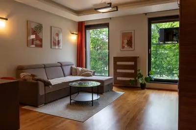 a living room with a couch and a table at Kraków Główny Apartment - Parking, Workspace - by Rentujemy in Kraków