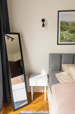 a bedroom with a mirror and a bed and a table at Kraków Główny Apartment - Parking, Workspace - by Rentujemy in Kraków