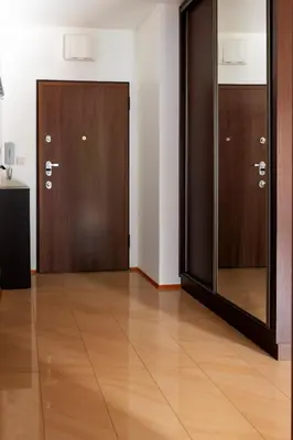 two brown doors in a room with wooden floors at Kraków Główny Apartment - Parking, Workspace - by Rentujemy in Kraków