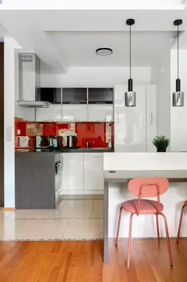 a kitchen with red and white cabinets and a pink chair at Kraków Główny Apartment - Parking, Workspace - by Rentujemy in Kraków