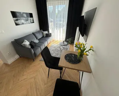 a living room with a couch and a table at DS Apartamenty Jaśminowa in Zator
