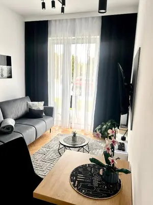 a living room with a couch and a table at DS Apartamenty Jaśminowa in Zator