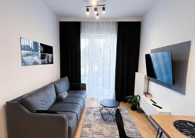 a living room with a couch and a table at DS Apartamenty Jaśminowa in Zator