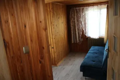 a small room with a blue bed and a window at Noclegi u Ewusi 2 in Januszowice