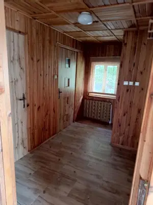 an empty room with wooden walls and a window at Noclegi u Ewusi 2 in Januszowice