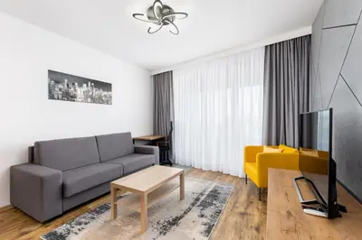a living room with a couch and a tv at Wiślane Tarasy 2 0 Chic Studio by BookingHost in Kraków