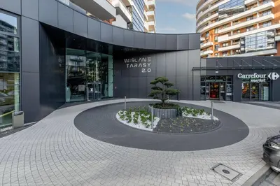 a tree in a circle in front of a building at Wiślane Tarasy 2 0 Chic Studio by BookingHost in Kraków