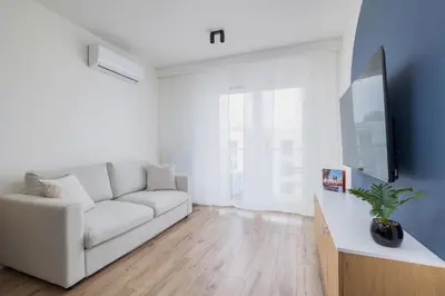 a living room with a white couch and a flat screen tv at Modern Apartment in Kraków Podgórze by Noclegi Renters in Kraków