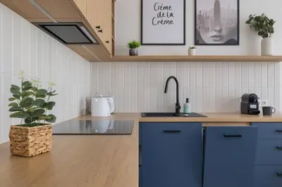 a kitchen with blue cabinets and a sink at Modern Apartment in Kraków Podgórze by Noclegi Renters in Kraków