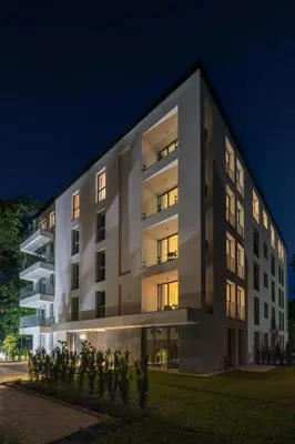a large building with lights on at night at Metropolis Old Town Apartments in Kraków