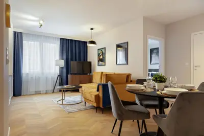 a living room and dining room with a dining table at Metropolis Old Town Apartments in Kraków