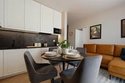 a kitchen and living room with a table and chairs at Metropolis Old Town Apartments in Kraków