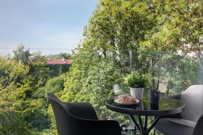 a table with a plate of food on a balcony at Metropolis Old Town Apartments in Kraków