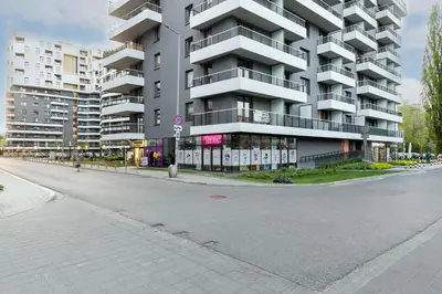 an empty street in front of a large apartment building at Bronowice Comfy Studio by BookingHost in Kraków