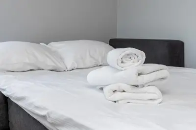 a bed with white towels stacked on it at Bronowice Comfy Studio by BookingHost in Kraków
