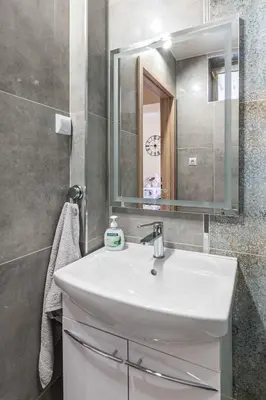 a bathroom with a white sink and a mirror at Apartament 45m2 - Sunny&Quiet - VERY CLOSE to Auschwitz Museum ! in Oświęcim