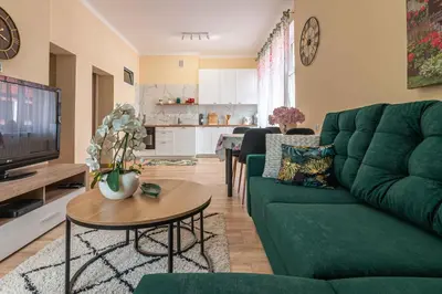 a living room with a green couch and a table at Apartament 45m2 - Sunny&Quiet - VERY CLOSE to Auschwitz Museum ! in Oświęcim