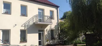 a white building with a balcony and a tree at Źródlana13 Apartamenty Maków Podhalański in Maków Podhalański