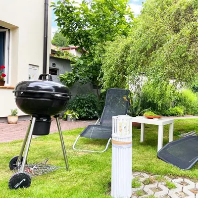 a grill in a yard with a table and chairs at Źródlana13 Apartamenty Maków Podhalański in Maków Podhalański