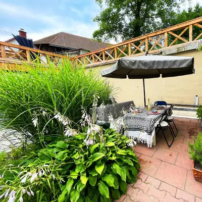 a patio with a table and an umbrella at Źródlana13 Apartamenty Maków Podhalański in Maków Podhalański