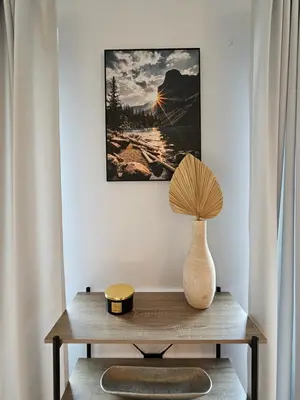 a table with a vase and a lamp on it at Bulwary Wiślane Kraków Apartament Ludwinowska przy Forum by Noclegi Renters in Kraków